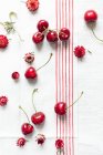 Frische Kirschen und rote Erdbeeren auf Leinentuch — Stockfoto