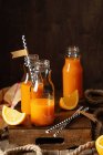 Свежий витаминный сок в маленьких банках (апельсиновый и морковный сок) — стоковое фото
