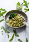 Спагетти с горохом и мятным песто, брокколи и копченым тофу — стоковое фото