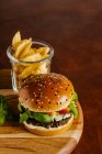 Blauschimmelkäse-Basilikum-Rindfleisch-Burger mit Senfsauce und Pommes frites — Stockfoto