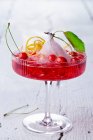 A cherry cocktail with gin, ginger ale and mini wild cherries — Stock Photo