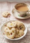 Cookies with pistachios and dried rose petals, served with a cup of coffee — Stock Photo