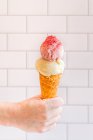 Woman with ice cream cone topped with strawberry fruit powder — Stock Photo
