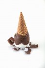Un cono de helado cubierto de chocolate inclinado al revés - foto de stock