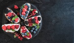Bruschettas mit Beeren und Frischkäse auf Teller — Stockfoto