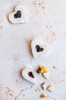 Galletas en forma de corazón con mermelada de frambuesa (y un corazón roto) - foto de stock