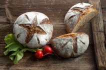 Две буханки каштанового хлеба на деревянной поверхности — стоковое фото