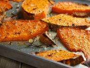 Pumpkins wedges roasted with garlic and rosemary — Stock Photo