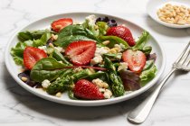 Asperges vertes avec salade de feuilles mélangées, fraises et fromage de brebis — Photo de stock