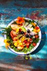 Летний салат с помидорами, огурцом, чили, оливками и съедобными цветами — стоковое фото