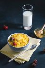 Porridge de maïs avec beurre et fraises dans un bol avec lait et miel — Photo de stock