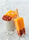 Crème glacée à la grenade à la mangue sur le manche avec glace concassée — Photo de stock