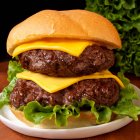 Close-up de delicioso cheeseburger duplo com alface — Fotografia de Stock