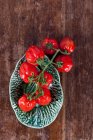 Маленькі сливові помідори в керамічній мисці — стокове фото