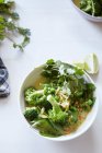 Tazón de ensalada verde con verduras frescas y hierbas - foto de stock