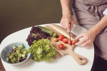 Salatzubereitung - Salat und Tomaten hacken — Stockfoto