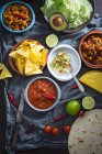 Веганские мексиканские блюда: гуакамоле с чипсами, сальса, выдернутые джекфруты, чили с карне — стоковое фото