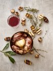 Coq au Vin avec moitiés de pommes de terre grillées, champignons, thym et un verre de vin rouge — Photo de stock