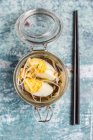 Soupe de ramen aux épinards, pousses de bambou, carottes, œufs et champignons dans un bocal en verre — Photo de stock