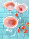 Strawberry and chili bellinis cocktails in glasses  on blue background — Stock Photo