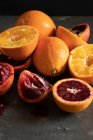 Oranges and blood oranges, partially juiced — Stock Photo