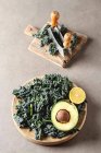 Fresh leaves of Kale salad with avocado and lemon — Stock Photo