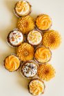 Cupcakes mit Vanille-Frischkäse Zuckerguss mit Zuckerstreusel und Blumen auf dem Tisch dekoriert — Stockfoto