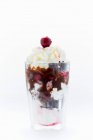Заморожений йогурт з шоколадним тортами, вишнями, шоколадним соусом та вершками — стокове фото