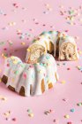 Bundt Kuchen mit weißer Glasur und bunten herzförmigen Zuckerstreuern zum Valentinstag — Stockfoto