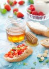 Strawberries, mint and hazelnuts on mascarpone toast with honey — Stock Photo