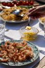 Espetos de camarão com molho de manteiga de manjericão, pasta cacio e pepe, macarrão com queijo e pimenta e tomate em uma mesa ao ar livre — Fotografia de Stock