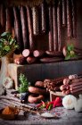 An arrangement of various game sausages, spices and herbs — Stock Photo