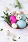 Перепелині яйця і кольорові великодні яйця в мисці — стокове фото
