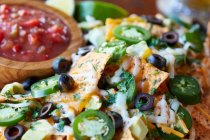 Nachos mit Käse, Jalapenos, schwarzen Oliven und Salsa (Mexiko)) — Stockfoto