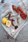 Limoni, pomodori, peperoncini e spezie su un panno di lino — Foto stock