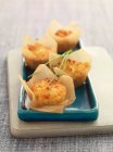 Savoury cheese and onion muffins in baking paper — Stock Photo