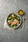 Лосось на гриле с овощами и соусом на тарелке — стоковое фото