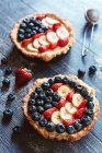 Obsttorten mit Erdbeeren, Blaubeeren und Bananenscheiben — Stockfoto