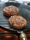 Burger patties in a grill pan — Stock Photo