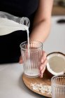 Pouring homemade coconut milk in the glass — Stock Photo