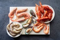 Assortiment de divers fruits de mer crus crevettes, moules kiwis, calmars et écrevisses — Photo de stock