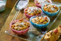Apple muffins with raisins in colorful paper cuffs — Stock Photo