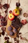 Ein herbstliches Arrangement aus Äpfeln, Feigen, Trauben und Schokolade — Stockfoto