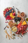 Deli-Platte mit Schinken, Käse, Hummus, Oliven, frischem Obst und Brot — Stockfoto