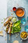 Hähnchen-Tikka-Spieße mit Masala-Sauce, Bombay-Kartoffeln, eingelegtem Zwiebel- und Gurkensalat und knusprigem Salat — Stockfoto