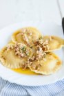 Pumpkin ravioli with melted butter and chopped walnuts — Stock Photo