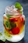 Water with fresh fruits, ice cubes and mint — Stock Photo