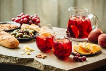 Sangria with fruit, olives and almonds — Stock Photo