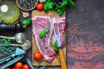 Raw T-bone steak avec différents ingrédients — Photo de stock