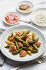 Fried green asparagus with chicken breasts in sweet and spicy sauce with rice and sesame seeds — Stock Photo